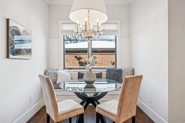 dining area with dark wood-type flooring and an inviting chandelier