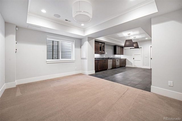 unfurnished living room with crown molding, dark carpet, and a tray ceiling