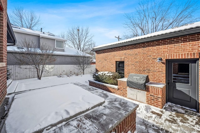 snow covered patio with area for grilling