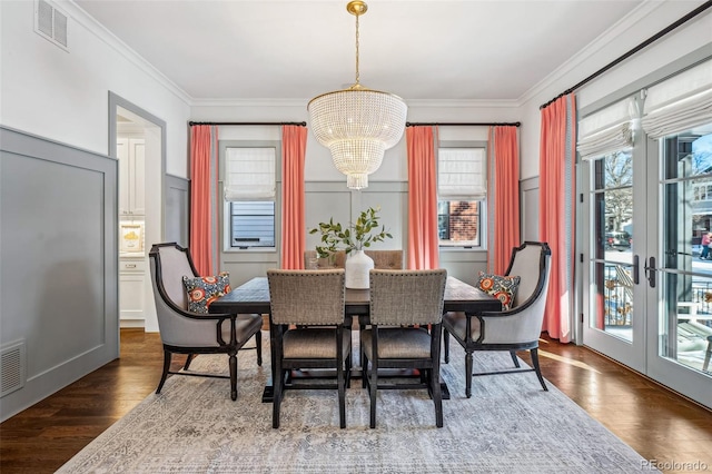 dining space featuring ornamental molding, dark hardwood / wood-style floors, and a chandelier