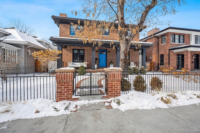 view of front of property featuring brick siding, a chimney, and a fenced front yard