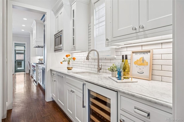 bar featuring crown molding, tasteful backsplash, appliances with stainless steel finishes, a sink, and wine cooler