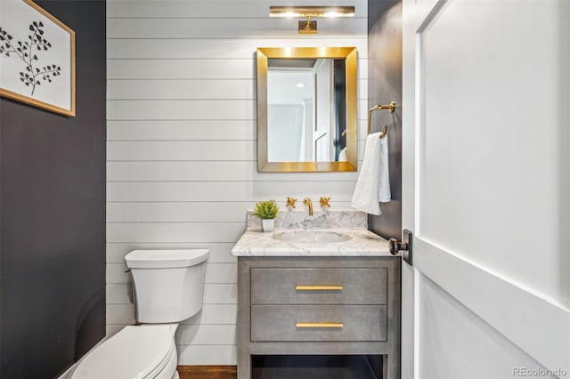 half bath featuring toilet and vanity