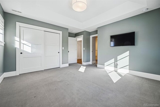 unfurnished bedroom with a closet, carpet flooring, baseboards, and visible vents