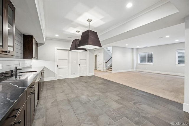 kitchen with pendant lighting, a sink, dark brown cabinets, and glass insert cabinets