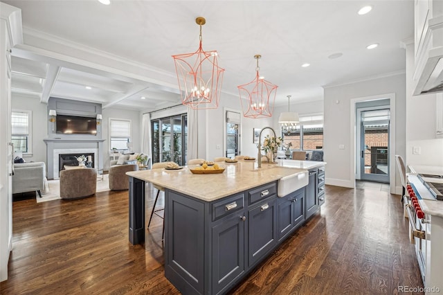 kitchen featuring recessed lighting, a sink, dark wood-style floors, and a kitchen breakfast bar