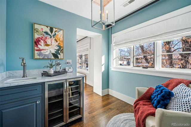 1131 S York St, Denver, CO 80210 - indoor bar with beverage cooler, a chandelier, dark wood-type flooring, baseboards, and pendant lighting