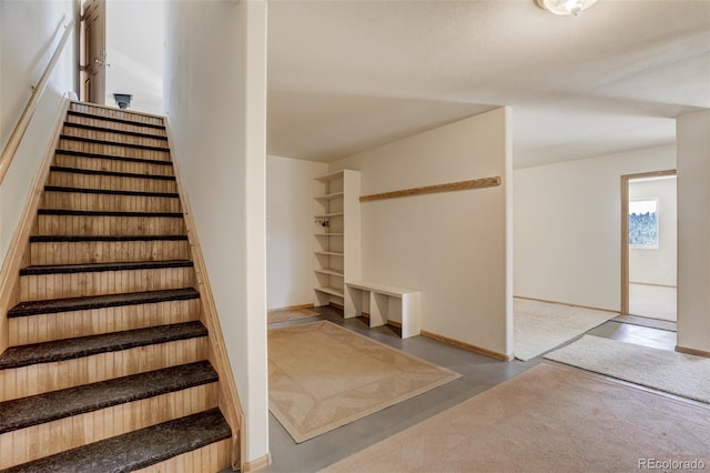 staircase featuring concrete floors