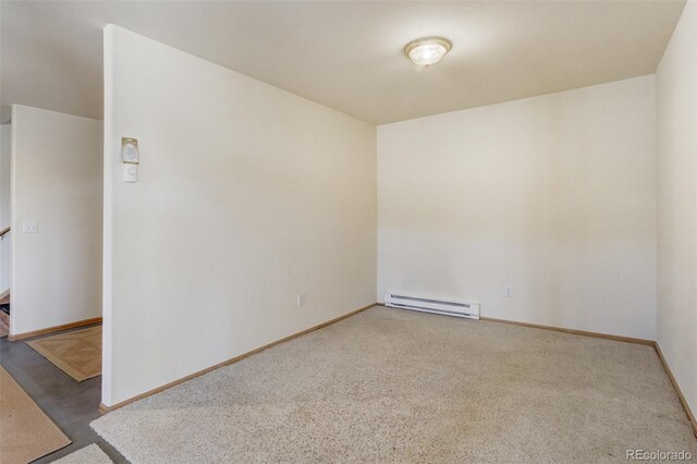 spare room featuring carpet and a baseboard heating unit