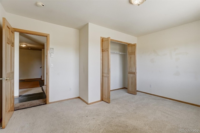 unfurnished bedroom featuring light colored carpet and a closet