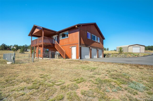 back of property with a yard, a garage, and a deck