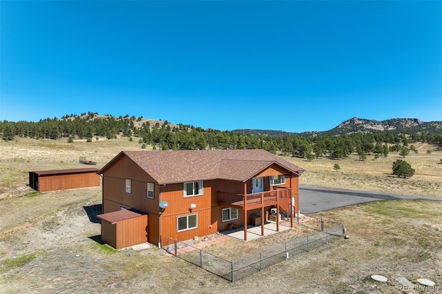 back of property with a mountain view and a rural view