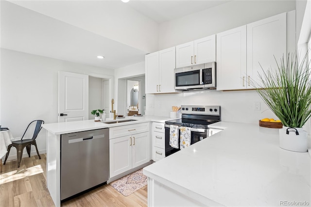 261 Knox Ct, Denver, CO 80219 - kitchen with appliances with stainless steel finishes, a peninsula, light countertops, and recessed lighting