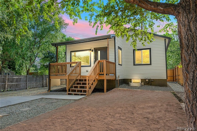 261 Knox Ct, Denver, CO 80219 - back of house at dusk with a fenced backyard and a wooden deck