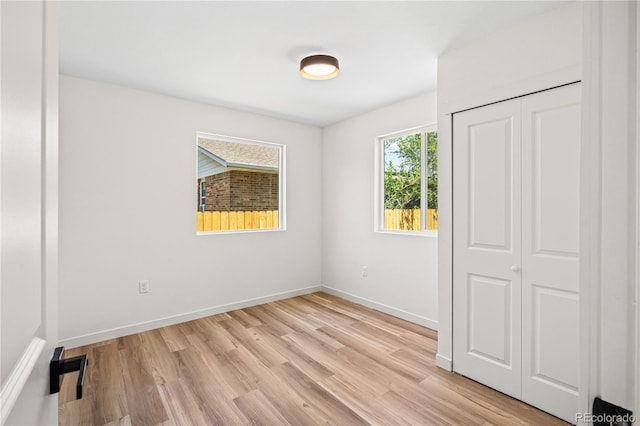 261 Knox Ct, Denver, CO 80219 - unfurnished bedroom with light wood-type flooring and a closet