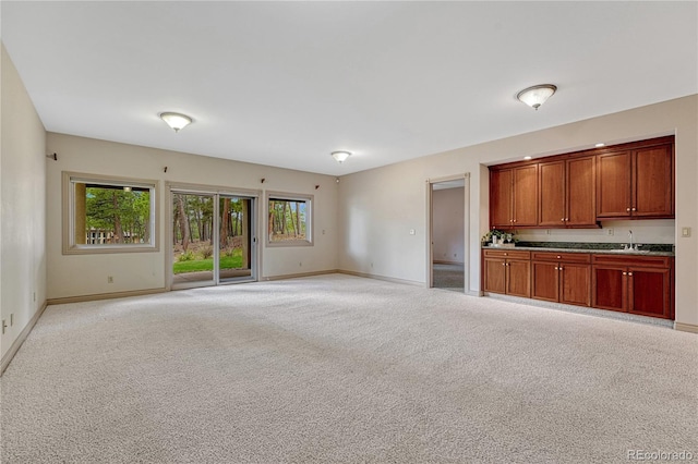 16150 Cliffrock Ct, Colorado Springs, CO 80921 - unfurnished living room featuring a sink, baseboards, and light colored carpet