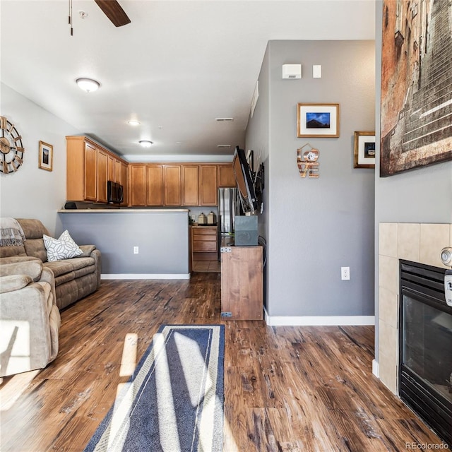 living room with dark hardwood / wood-style flooring, a fireplace, and ceiling fan