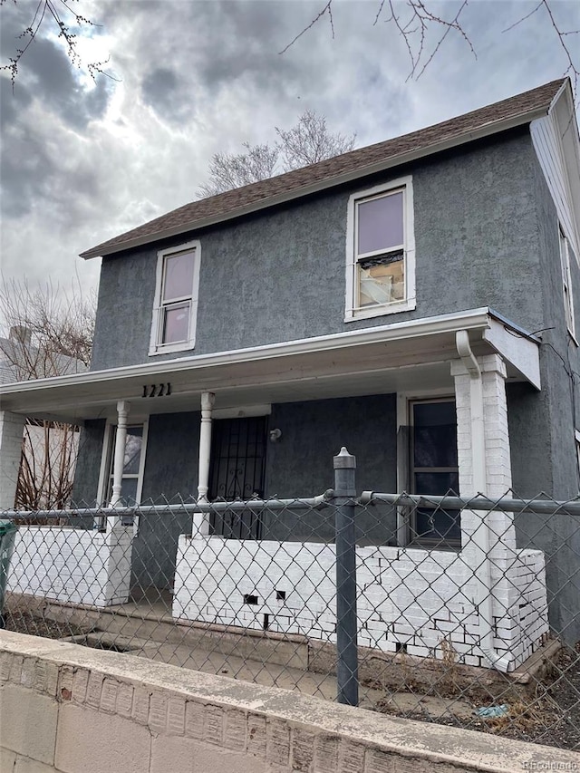 view of front facade featuring covered porch, a shingled roof, fence, crawl space, and stucco siding