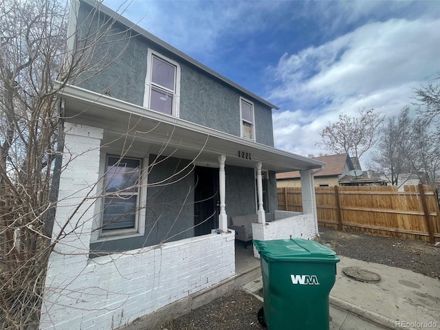 view of home's exterior with brick siding, fence, and stucco siding