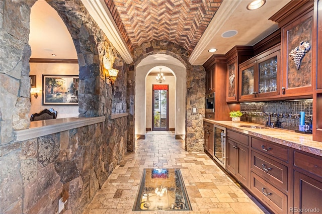 bar with beverage cooler, brick ceiling, tasteful backsplash, ornamental molding, and light tile floors