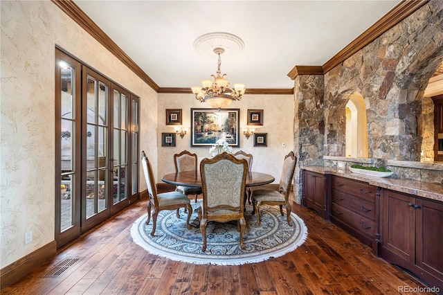 dining room with a notable chandelier, dark hardwood / wood-style flooring, and crown molding