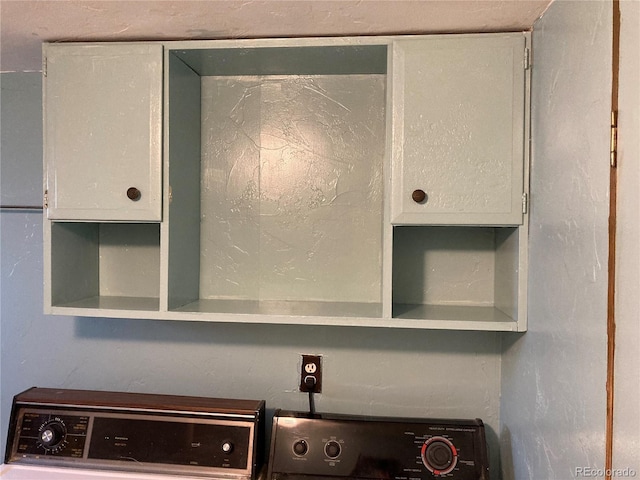 room details with washer / dryer and white cabinetry