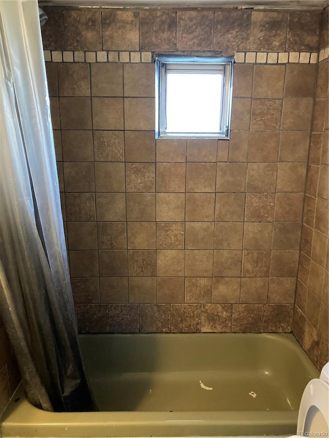 bathroom featuring shower / bath combo with shower curtain and toilet