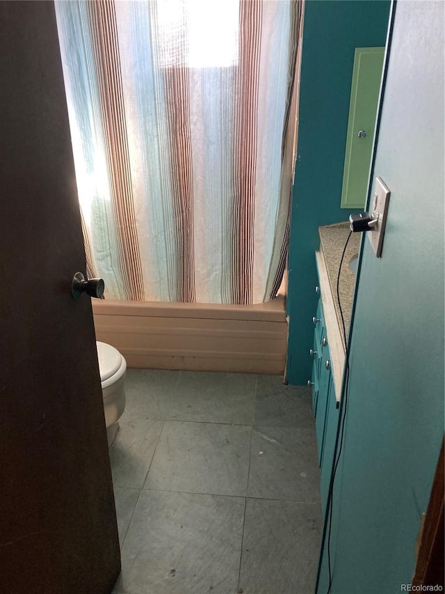 full bathroom featuring tile patterned flooring, shower / tub combo with curtain, vanity, and toilet