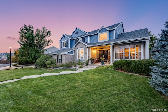 traditional home with a front lawn and roof with shingles