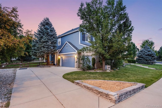 view of front of home with an attached garage, a yard, and driveway