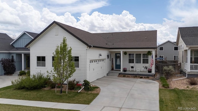 view of front of house featuring an attached garage, concrete driveway, a porch, and a front lawn