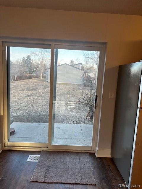 doorway featuring dark wood finished floors, baseboards, and visible vents