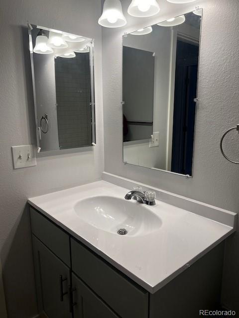 bathroom featuring vanity and a textured wall