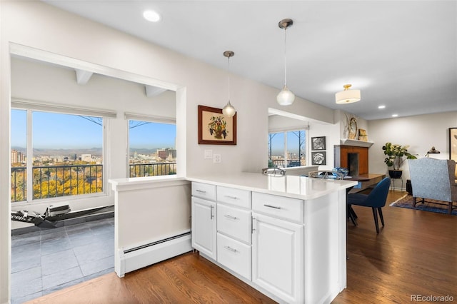 1200 N Humboldt St Unit 1003, Denver, CO 80218 - kitchen featuring a baseboard heating unit, a peninsula, open floor plan, a fireplace, and white cabinets