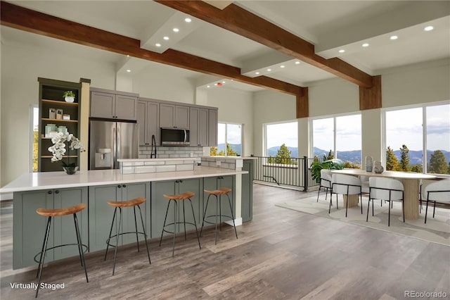 586 Alpine Way, Idaho Springs, CO 80452 - kitchen featuring appliances with stainless steel finishes, gray cabinets, beamed ceiling, decorative backsplash, and light wood-type flooring