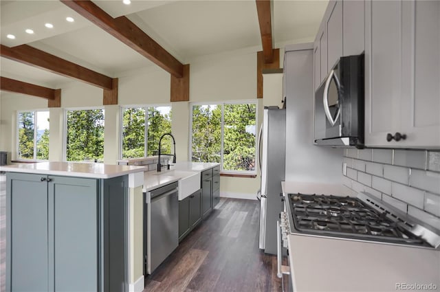 586 Alpine Way, Idaho Springs, CO 80452 - kitchen featuring stainless steel appliances, a center island with sink, beamed ceiling, decorative backsplash, and light countertops