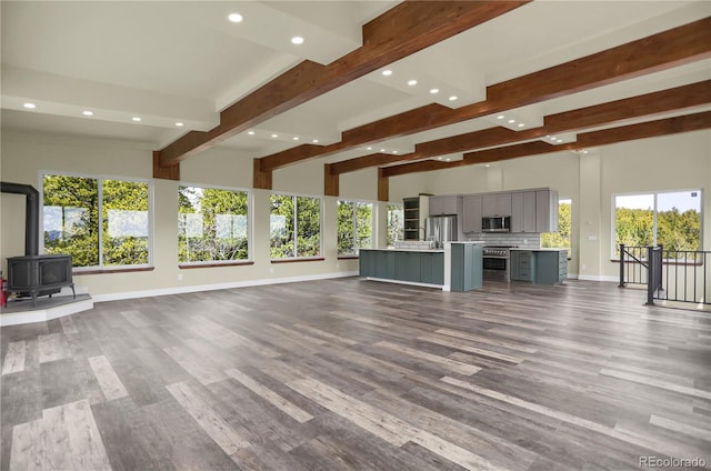 586 Alpine Way, Idaho Springs, CO 80452 - unfurnished living room with recessed lighting, beam ceiling, a wood stove, and wood finished floors
