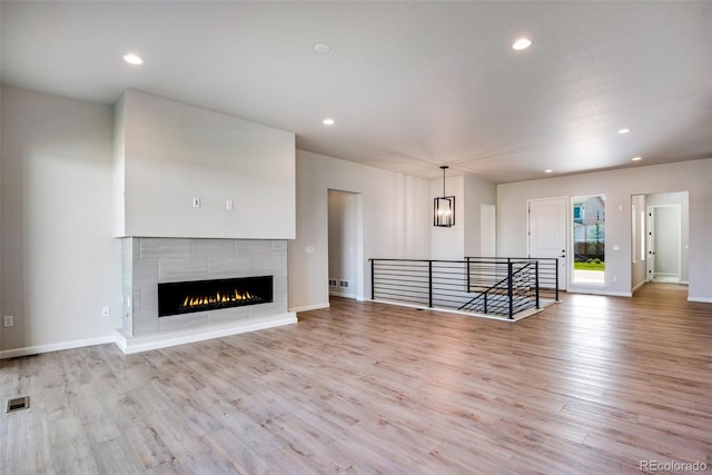 unfurnished living room with a fireplace and light hardwood / wood-style flooring