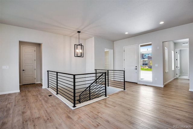 entrance foyer with an inviting chandelier and light hardwood / wood-style flooring