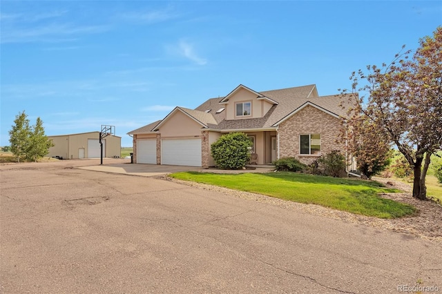 14825 Almstead St, Hudson, CO 80642 - view of front of home with a garage, driveway, roof with shingles, brick siding, and a front yard