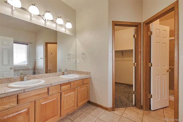 14825 Almstead St, Hudson, CO 80642 - bathroom with tile patterned flooring, double vanity, a spacious closet, and baseboards