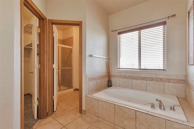 14825 Almstead St, Hudson, CO 80642 - bathroom featuring a stall shower, a jetted tub, tile patterned floors, and a spacious closet