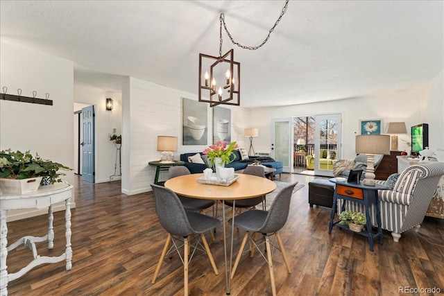 dining room with a notable chandelier, baseboards, and dark wood-type flooring