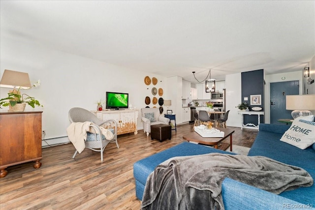 living area with a baseboard heating unit and wood finished floors