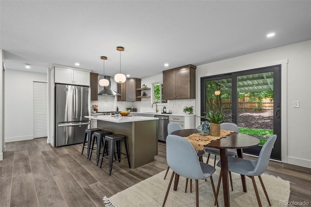 10067 W 68th Pl, Arvada, CO 80004 - kitchen featuring appliances with stainless steel finishes, open shelves, a kitchen island, light countertops, and tasteful backsplash