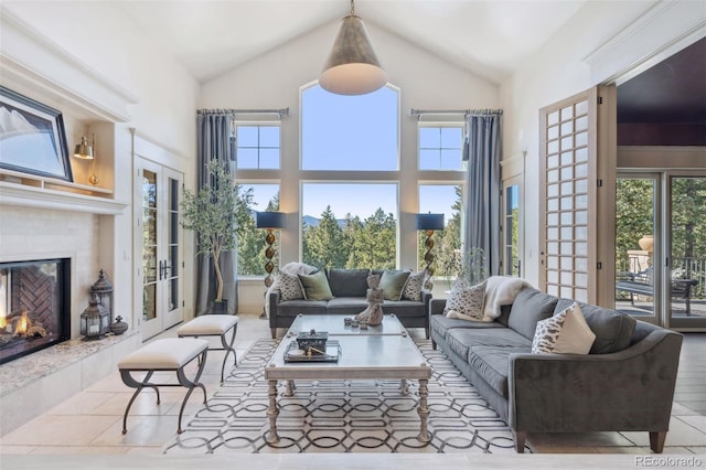 living room featuring high vaulted ceiling and a tile fireplace