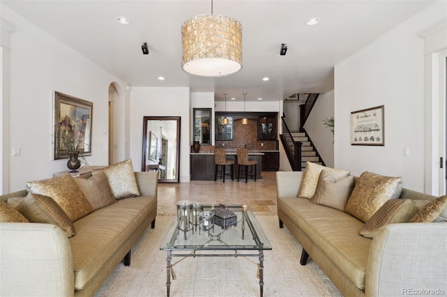living area featuring recessed lighting, arched walkways, and stairway