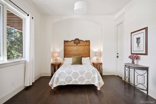 bedroom with baseboards and dark wood finished floors