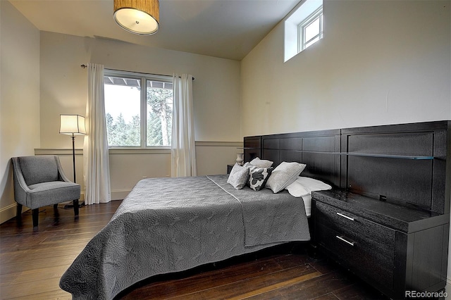 bedroom with multiple windows and dark wood-style floors