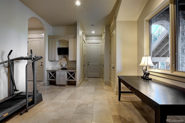 interior space featuring arched walkways, baseboards, and recessed lighting